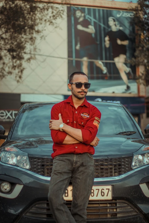 a smiling man standing next to a black vehicle