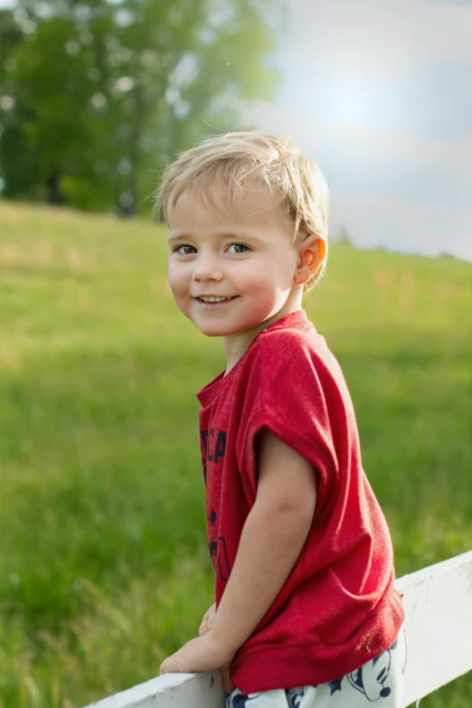 a  is smiling for a pograph in the grass