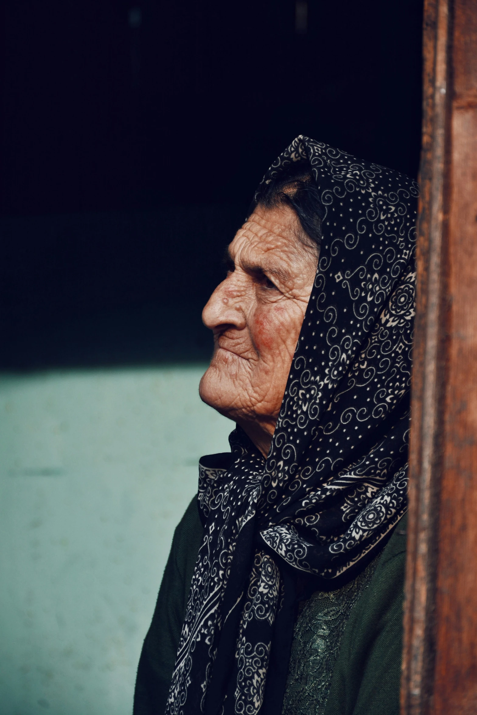 a woman with scarf looking out her window