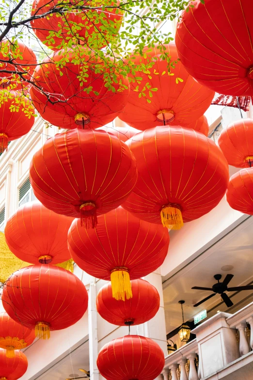 lots of red paper lanterns with golden ribbon and designs