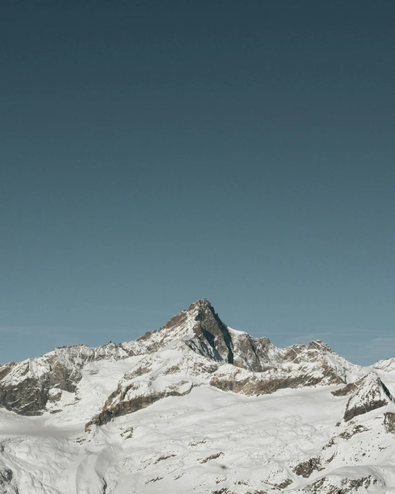 a person skiing down a hill with mountains in the background