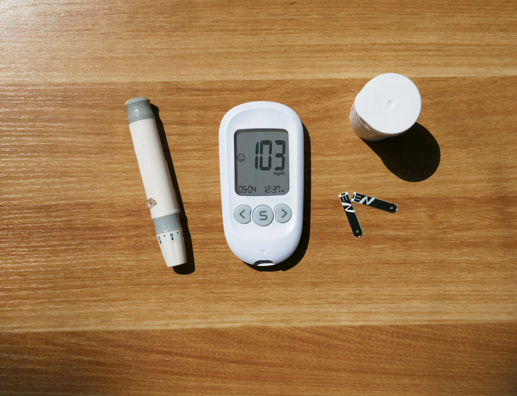 a thermometer sitting on top of a wooden table next to a cup