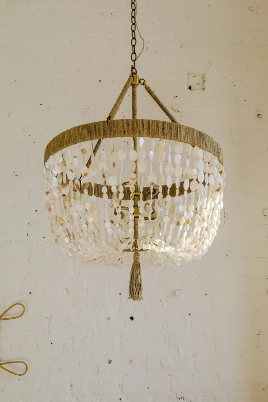 a chandelier hanging from a chain made with pearls