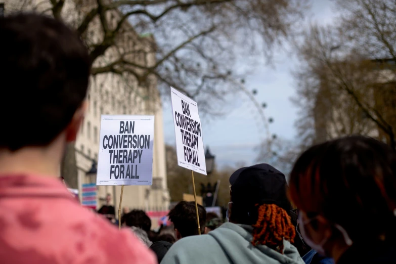 a crowd of people with protest signs standing in front of a building