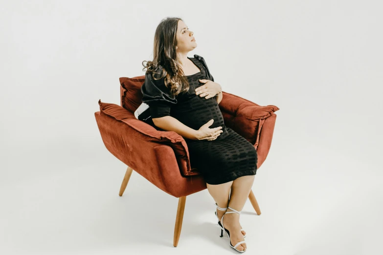 a pregnant woman sitting in a red chair