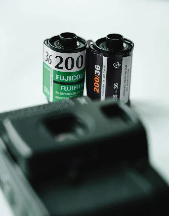 two batteries are shown next to a digital camera