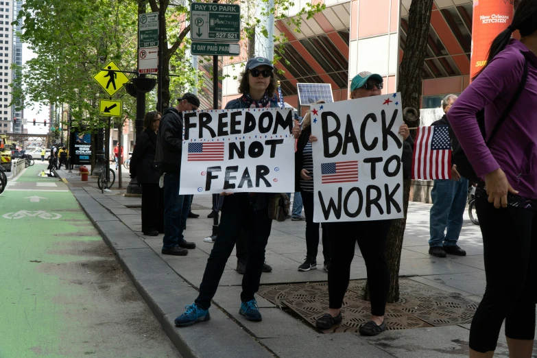 people are holding signs during a protest on a city street