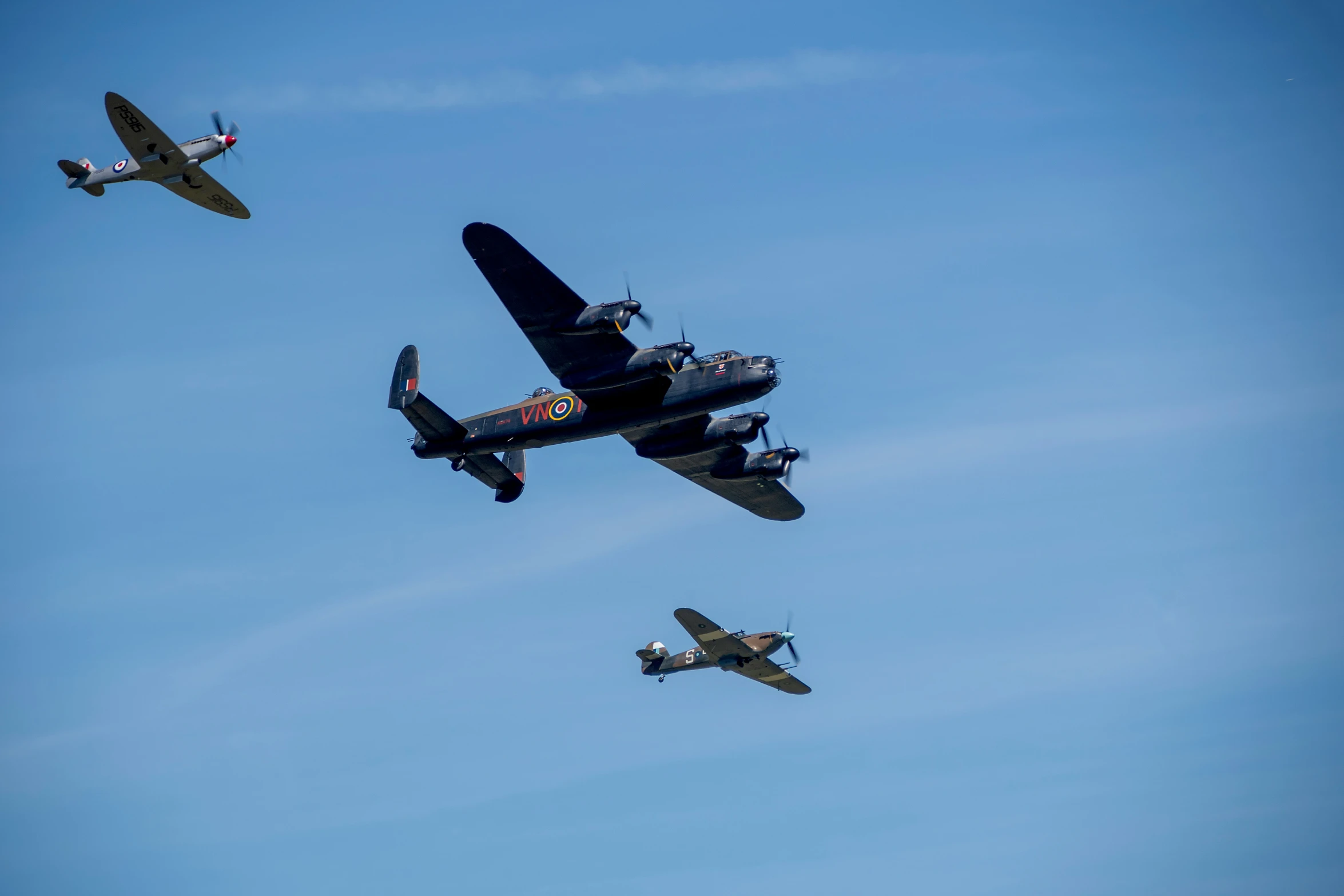 three biplanes are flying in formation against a blue sky