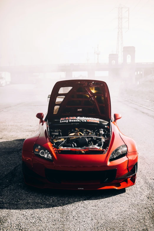 a sports car with the hood open on a foggy day