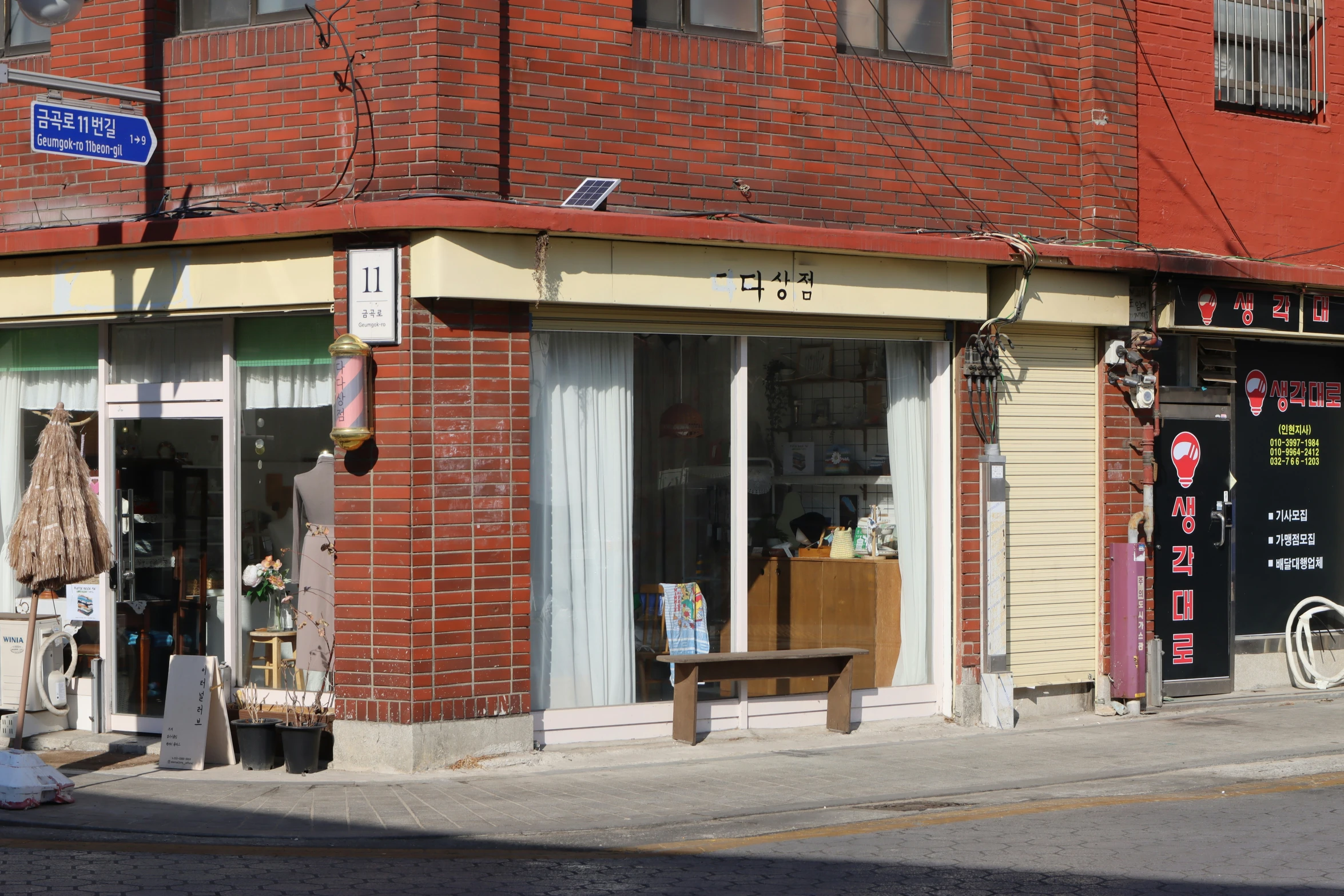 an empty street next to a building with a small bench