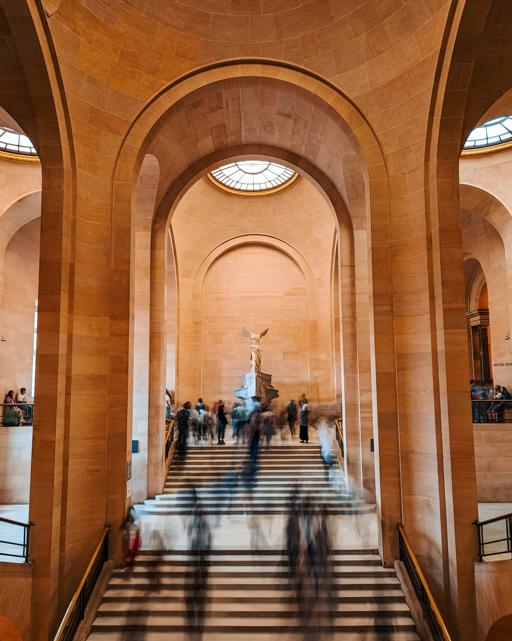 a number of people walking up stairs with a clock on each