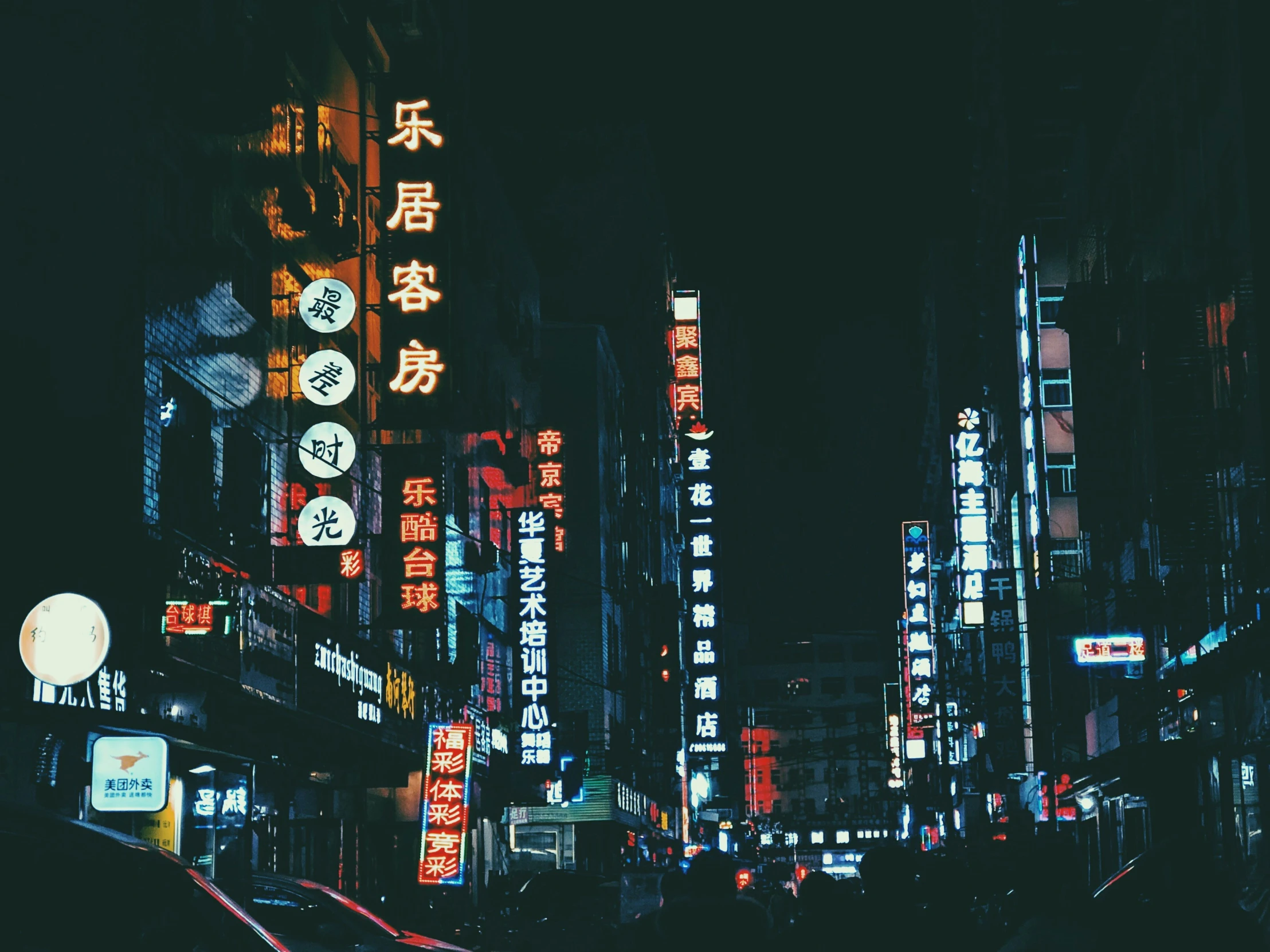 a night time city street with traffic and signs