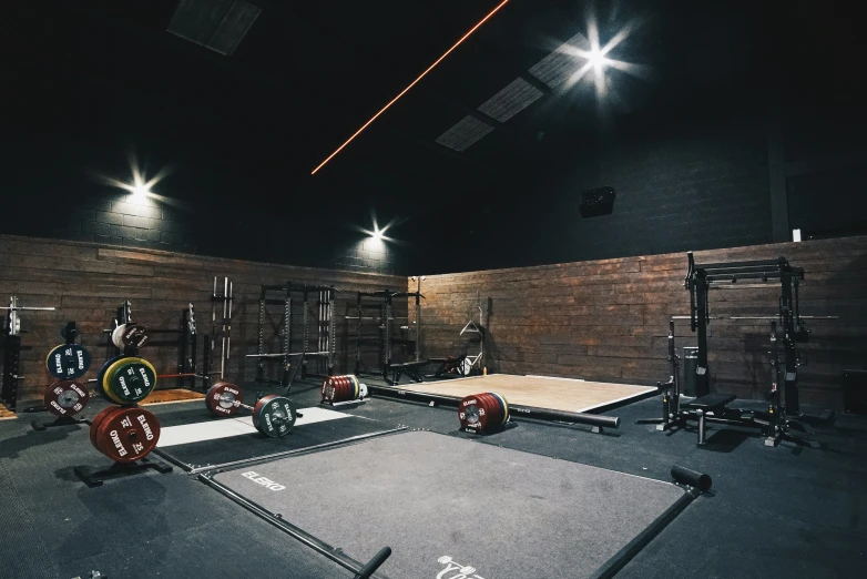 a dark room has a gym with various exercise mats and equipment