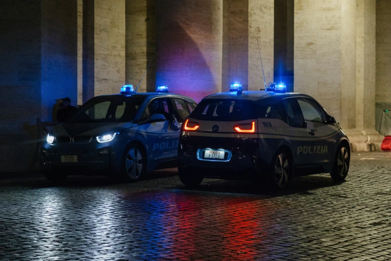 two police vehicles sitting on the side of the road at night