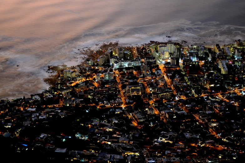 an aerial view of a city at night with some clouds