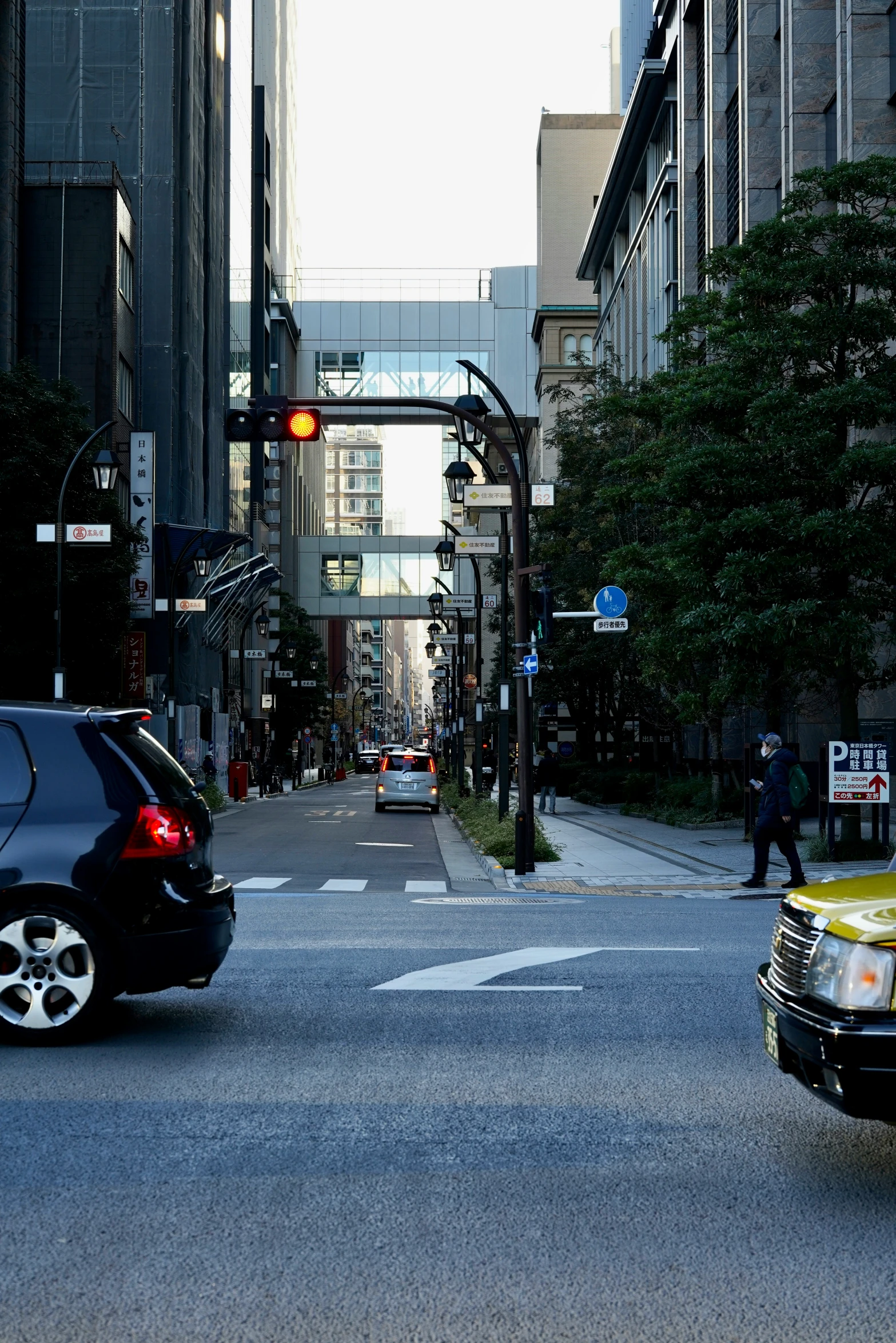 an image of a city street scene with cars and pedestrians