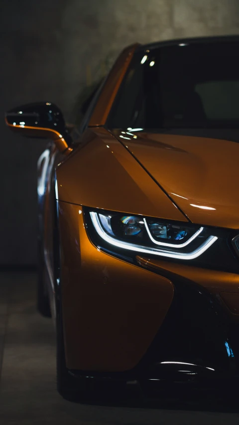 an orange car is parked in a dark room