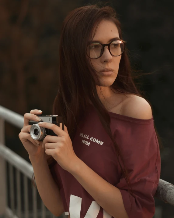 a girl wearing glasses taking a po of herself