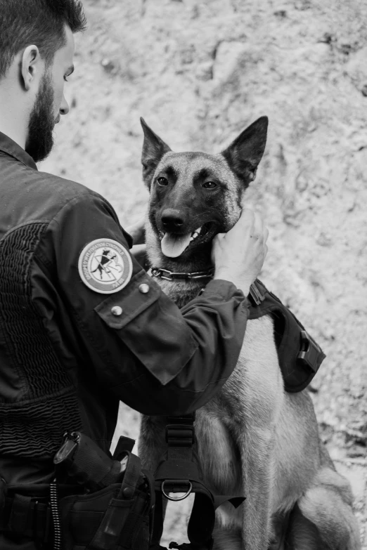 the policeman holding the dog is getting his picture taken