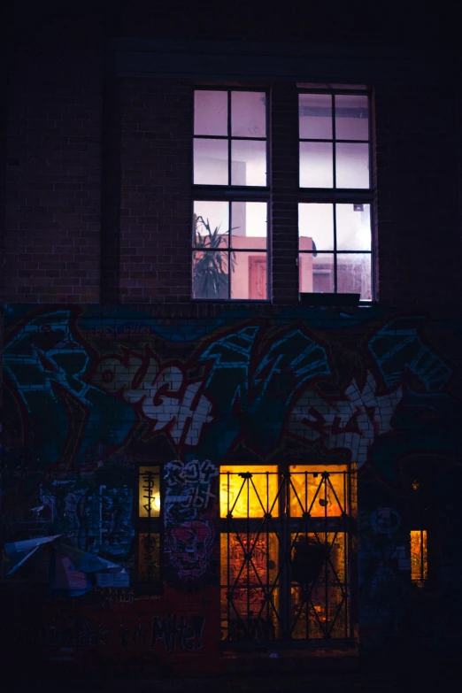 a building with a window is illuminated by the night sky