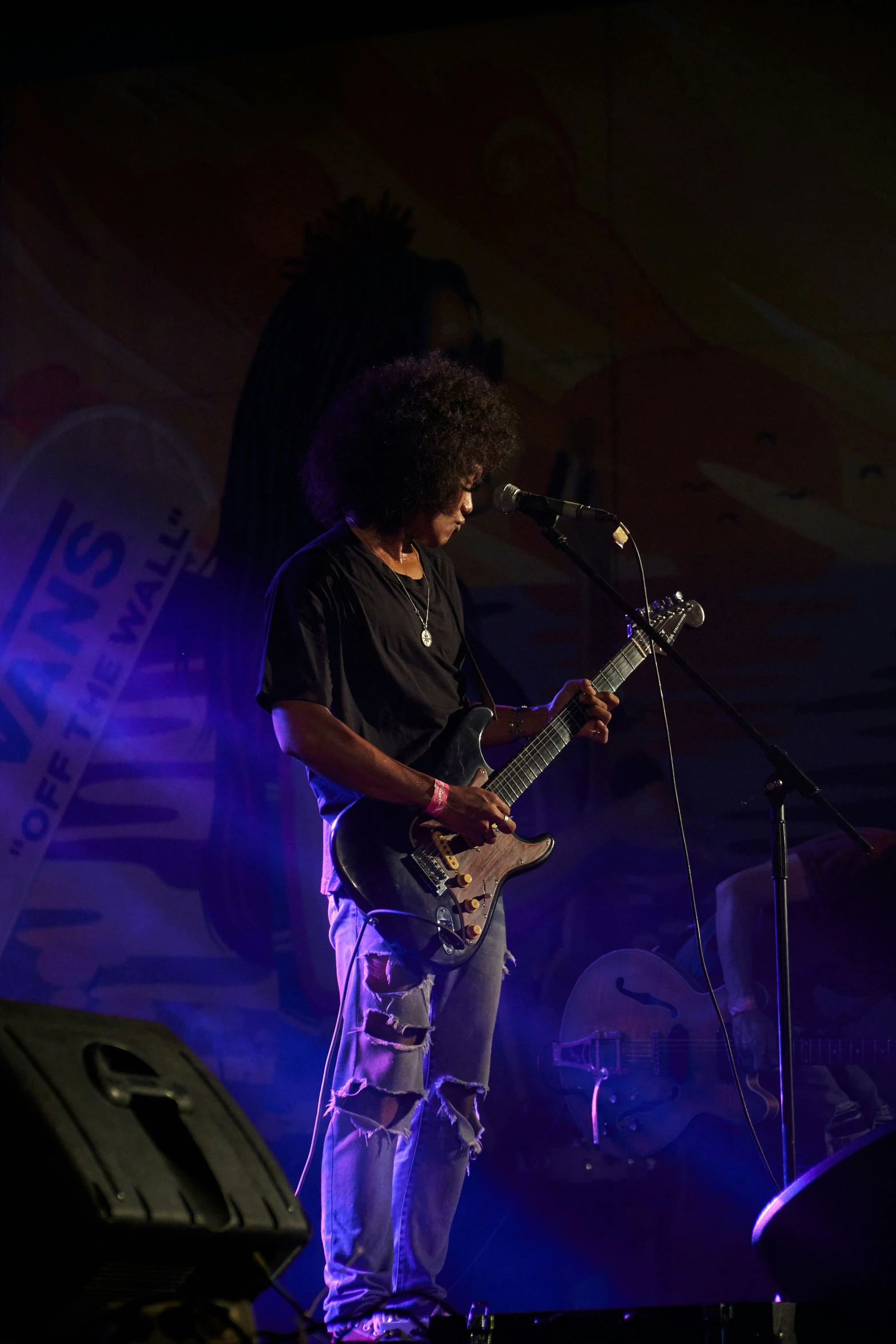 a man playing an electric guitar on a stage