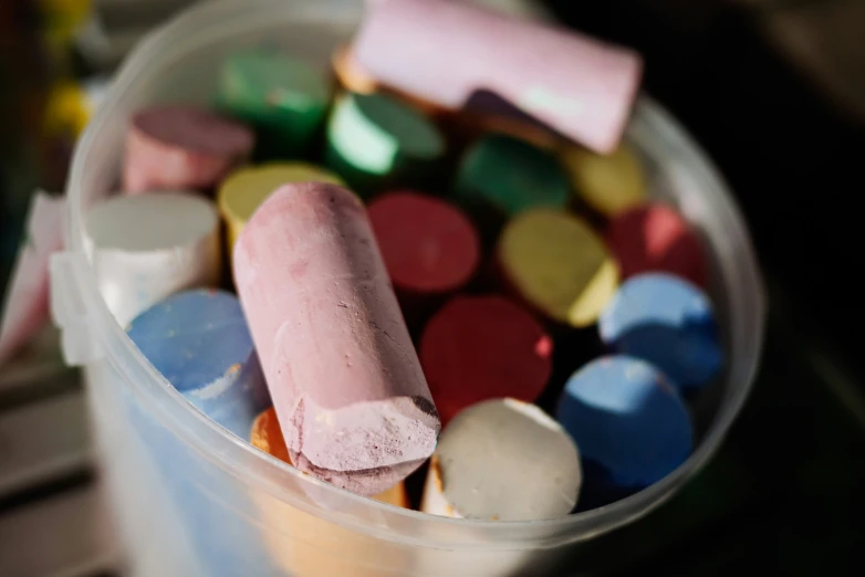 a plastic bucket with multicolored candy and colored candies