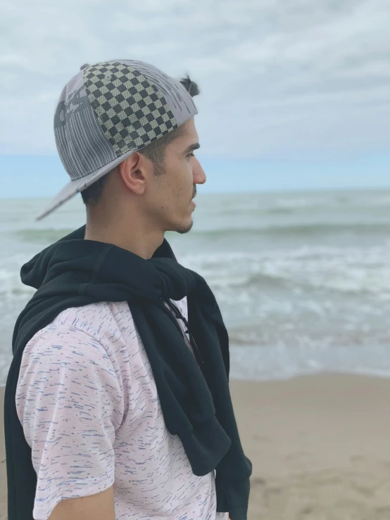 man standing on the beach with a towel wrapped around his neck