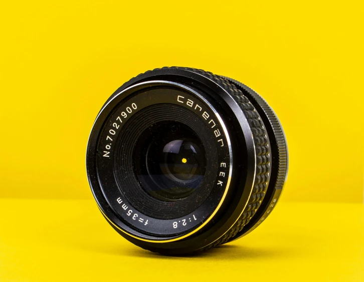 a black lens sitting on top of a yellow background