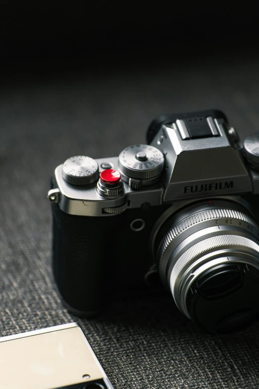 a black camera with a red lens sitting on the floor