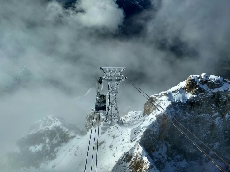 a large tower near a mountain with snow