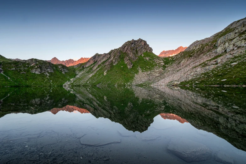 a body of water surrounded by mountains with snow