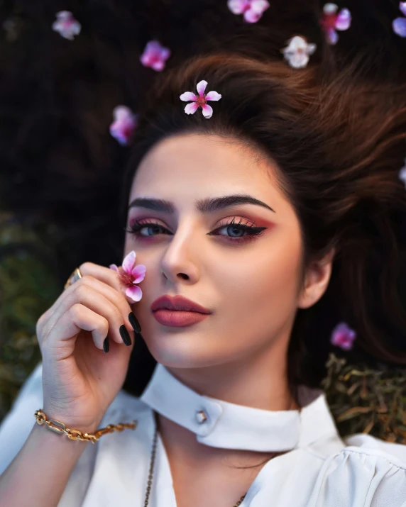 a woman with pink flowers around her head is posing