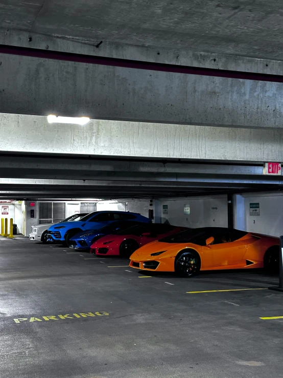 there are many exotic cars parked in the parking garage