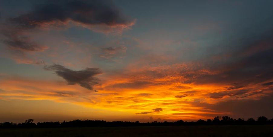 a sunset seen through clouds, and grass