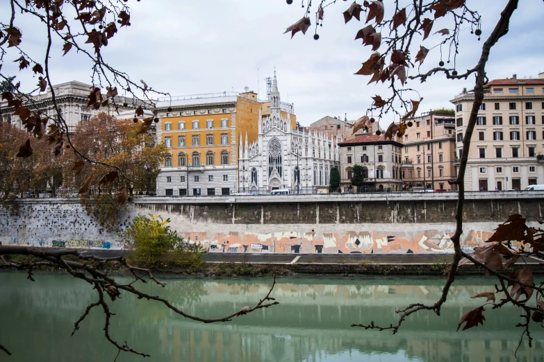 some buildings are shown behind trees near the water