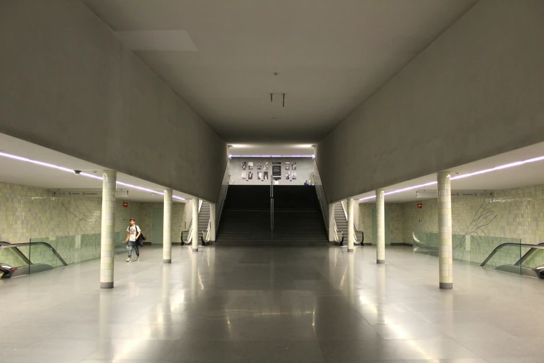 people walk around in a very large empty subway station