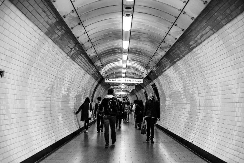 people walking on a subway platform with bicycles