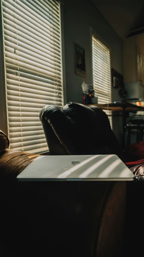 a laptop computer is resting in a leather chair