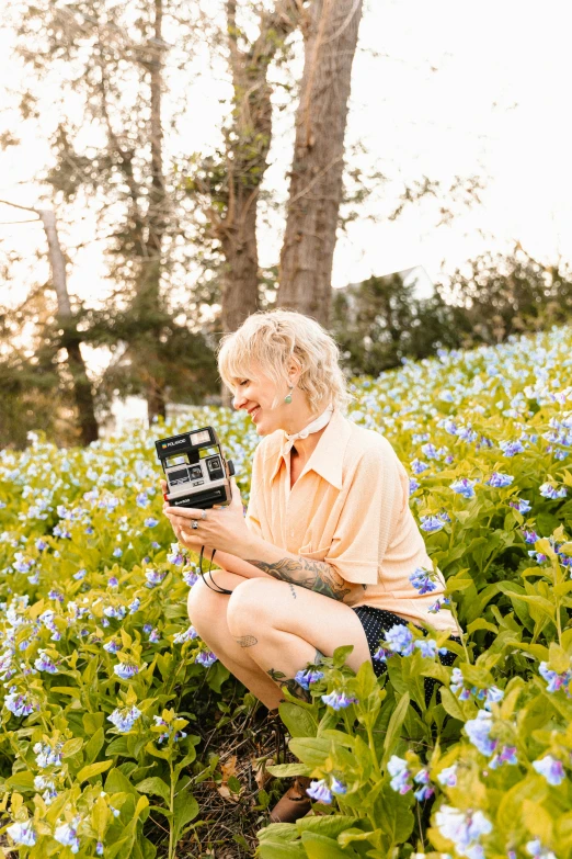 a woman kneeling down holding a small camera