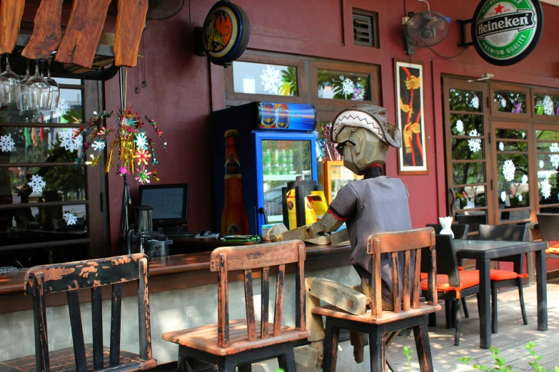 two chairs outside a restaurant with a person wearing a mask