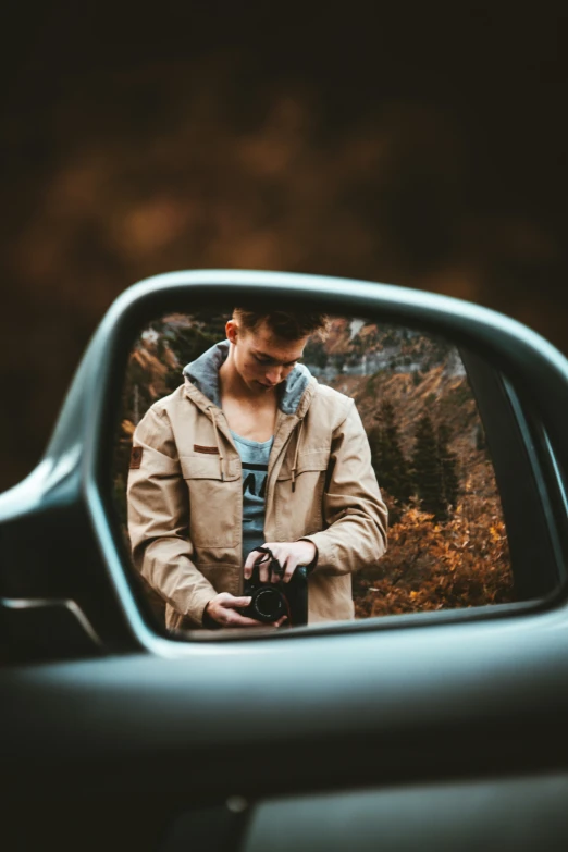 man is holding a camera in the mirror while taking a po