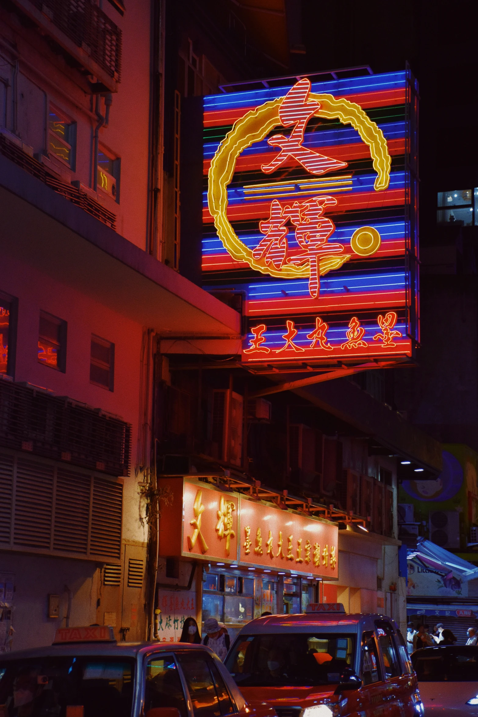 brightly lit signs sit over cars in an oriental city at night