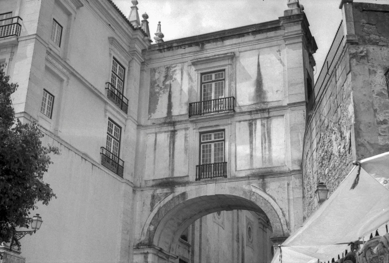 some people standing outside an old building with umbrellas