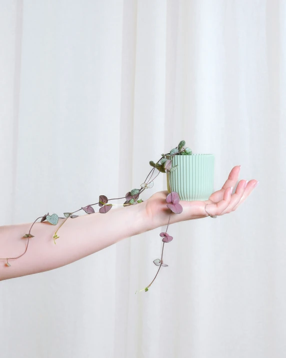 a woman's arm with a green cup sitting on top of it