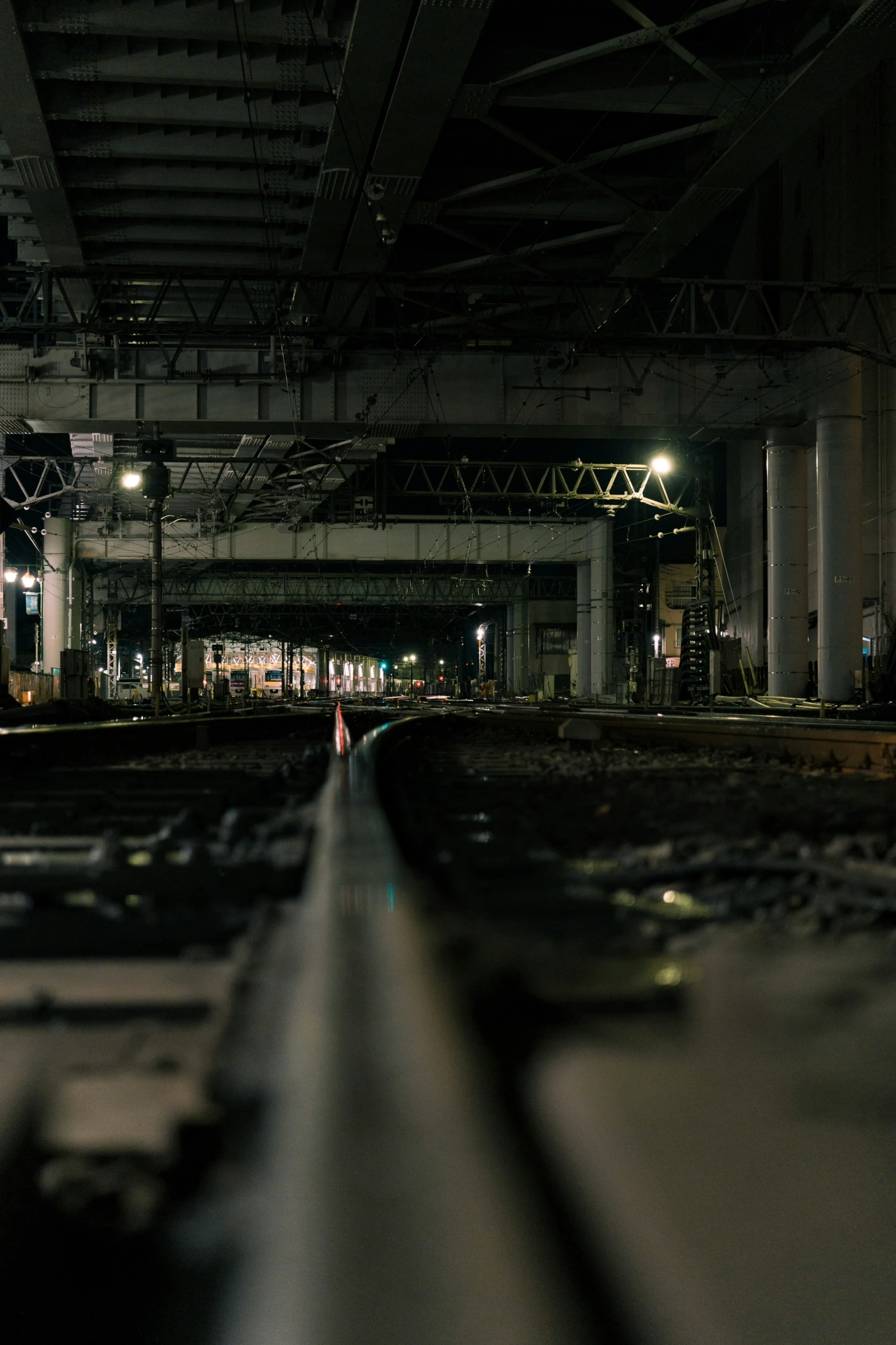 an empty train track in a very large train station