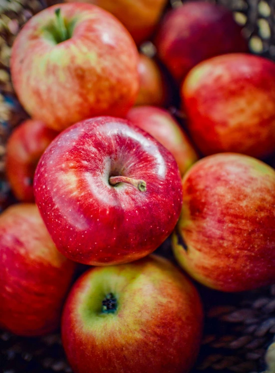 a bowl full of apples sit side by side