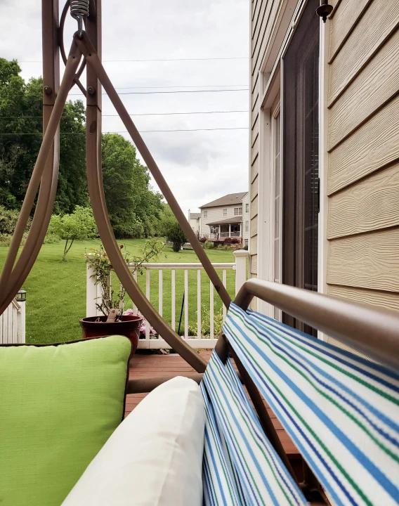 green and blue pillows sit on an outdoor wooden deck