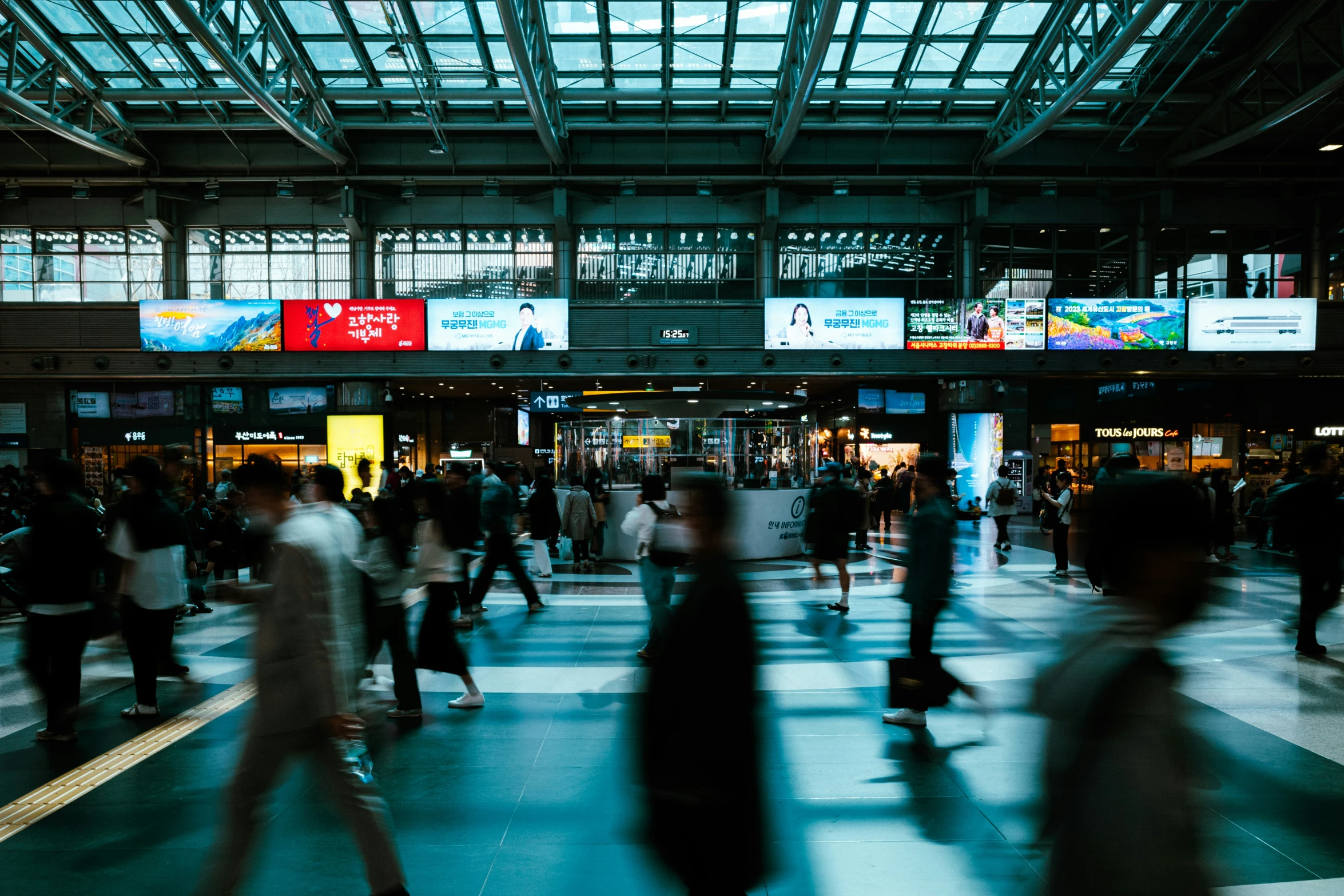 an indoor train station with many people walking about