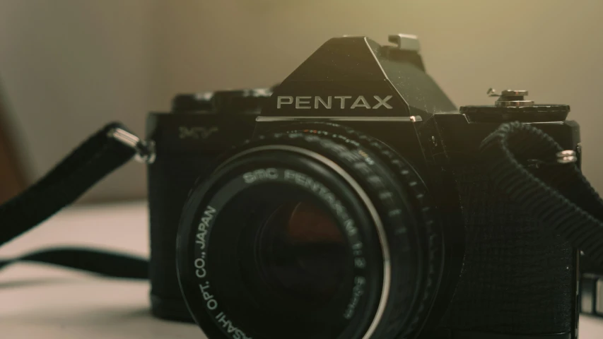 closeup of pentax camera on white table with room for text