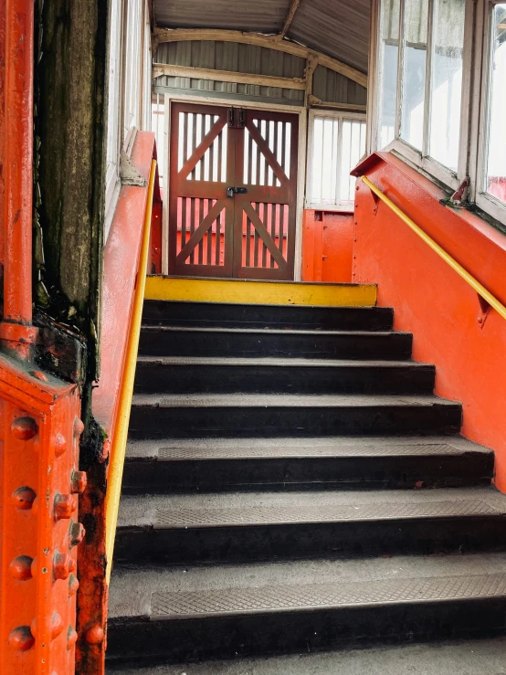 steps leading up to a doorway with red railing